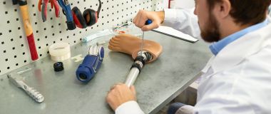 En ortopeditekniker skrur på en beinprotese 