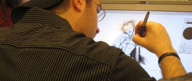 En animatør sit foran ein skjerm og teiknar.