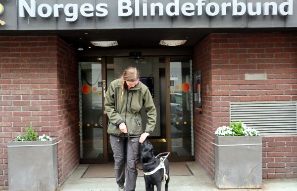 Carita og hunden foran inngangen til Norges Blindeforbund. Nå skal de ut på trening i Oslos bygater. 