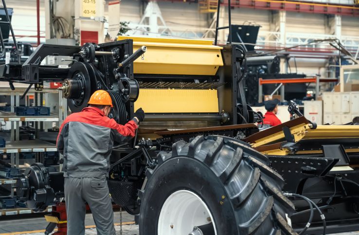 En landbruksmaskinmekaniker monter en stor maskin