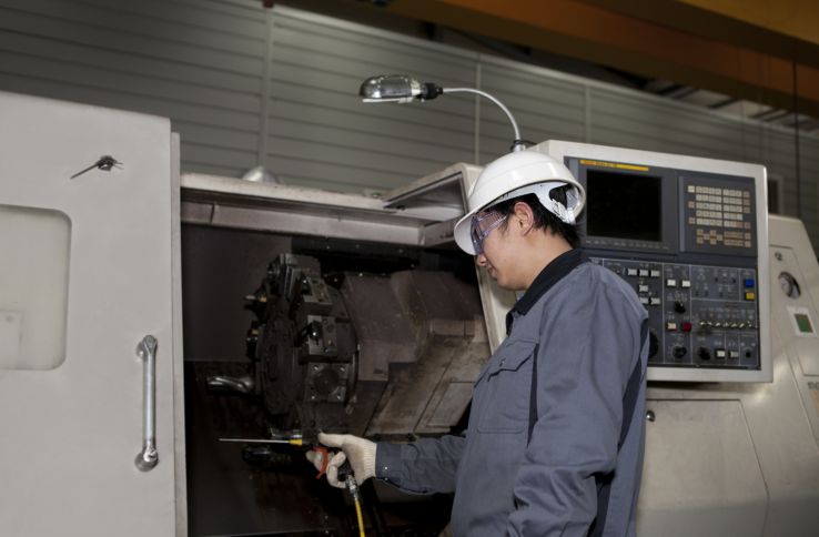 CNC-operatør jobber ved ei CNC-maskin