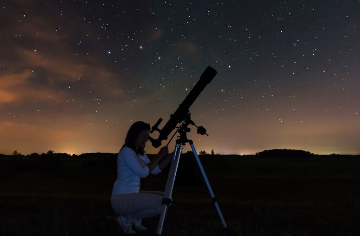 En astronom kikker på stjernene på nattehimmelen.