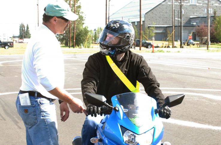 Trafikklærer underviser motorsyklist.