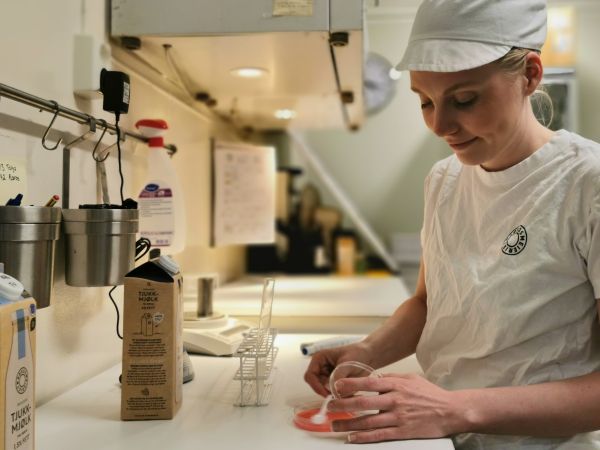Matteknolog Hanna Østvik i hvit T-skjorte og hvit caps jobber med prøvetaking på laboratoriet