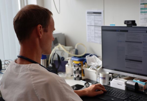 lege Øystein Seth Fiskå foran dataskjermen på kontoret.