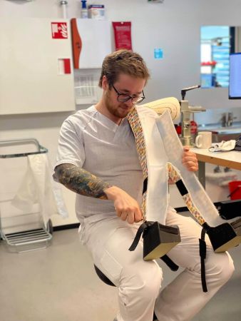Mann i helsearbeiderklær jobber på en plastform av bena til et barn.