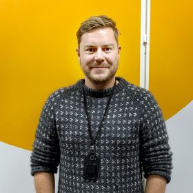 Nettverksadministrator Helge Andreas Granlund smiler, med ansattkortet sitt rundt halsen.