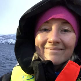 Fiskehelsebiolog Oda Klingenberg er iført redningsvest ute på sjøen.