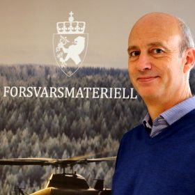 Portrett av Jon Harald Stovner foran logoen til forsvarsmateriell. 