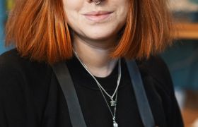 Portrettfoto av ung kvinne med rødlig hår og nesering