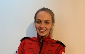 Ambulansearbeider Amalie Kjærstad med lys hestehale og rød uniformsjakke 