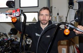 Motorsykkelmekaniker Tadeusz Kedzior poserer på en Harley han har til overhaling på verkstedet.  