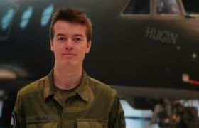 Simon Andreas i militærunimform foran et militært fly