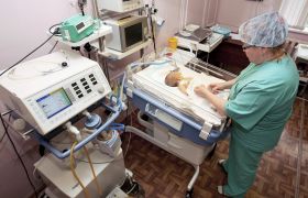 En kirurg ser til et for tidlig født barn i en inkubator. Inkubatorer brukes til for tidlig fødte (premature) barn, eller barn som er syke.