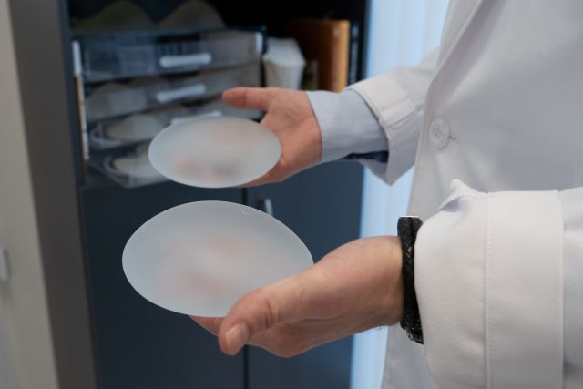 Plastikkirurg Børge Davik holder to silikonproteser som skal i bryst.