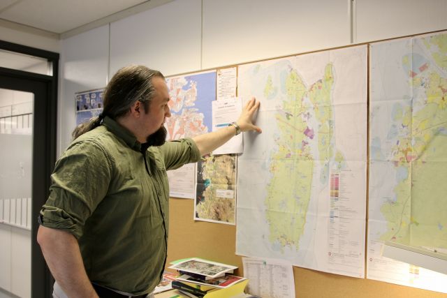 Samfunnsplanlegger Håkon Randal foran et kart over Karmøy kommune