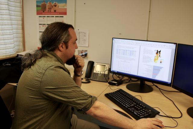 Samfunnsplanlegger Håkon Randal foran pc-skjermer på kontoret