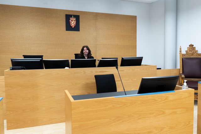 Tingrettdommer Hanne Ombudstvedt sitter på plassen sin øverst i rettssalen med dataskjermer foran seg