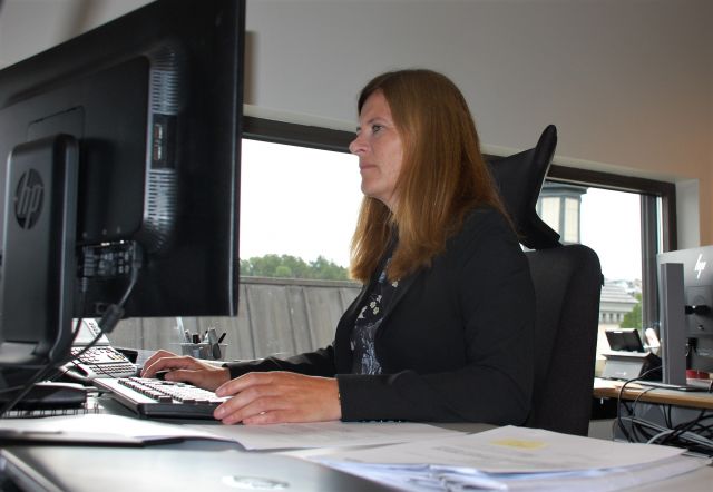 Siv Merete Hagen jobber foran PC-skjermene på kontoret sitt.
