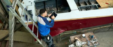 En komposittbåtbygger reparerer en båt