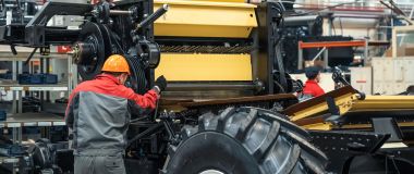 En landbruksmaskinmekaniker monter en stor maskin