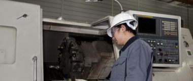 CNC-operatør jobber ved ei CNC-maskin