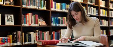 Filolog studerer en bok på et bibliotek