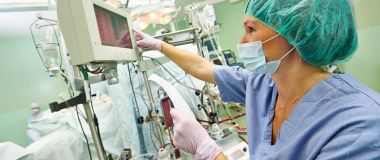 En perfusjonist følger med på en maskin under en hjerteoperasjon
