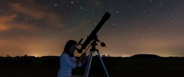 En astronom kikker på stjernene på nattehimmelen.