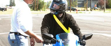 Trafikklærer underviser motorsyklist.